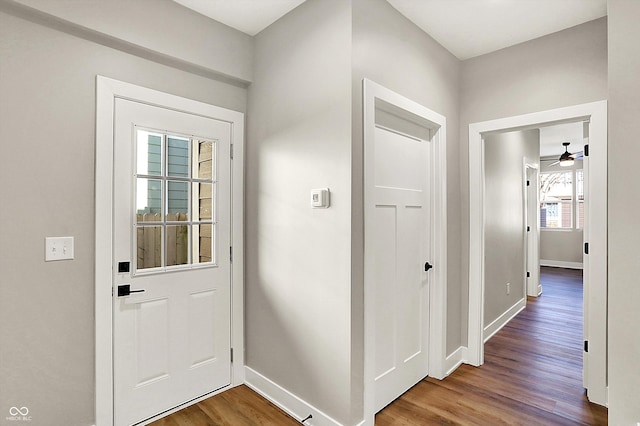 entryway featuring wood finished floors, a ceiling fan, and baseboards