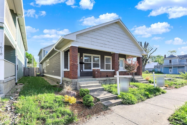 1622-1624 Prospect St, Indianapolis, IN 46203 - bungalow-style house featuring fence, covered porch, and brick siding