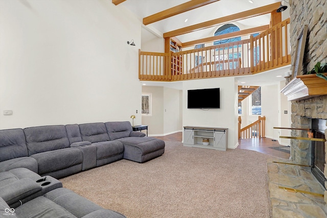 living room featuring a towering ceiling, carpet flooring, beam ceiling, and a fireplace