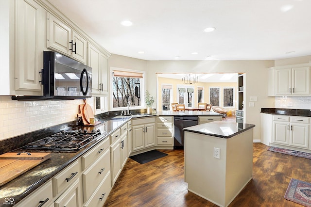 kitchen featuring stainless steel gas stovetop, black dishwasher, a kitchen island, backsplash, and dark hardwood / wood-style floors