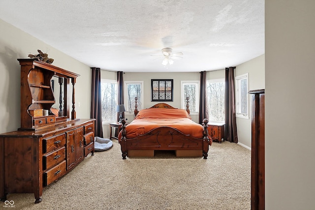 carpeted bedroom with multiple windows, a textured ceiling, and ceiling fan