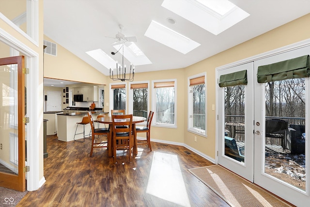 dining space featuring a notable chandelier, french doors, dark hardwood / wood-style flooring, and vaulted ceiling with skylight