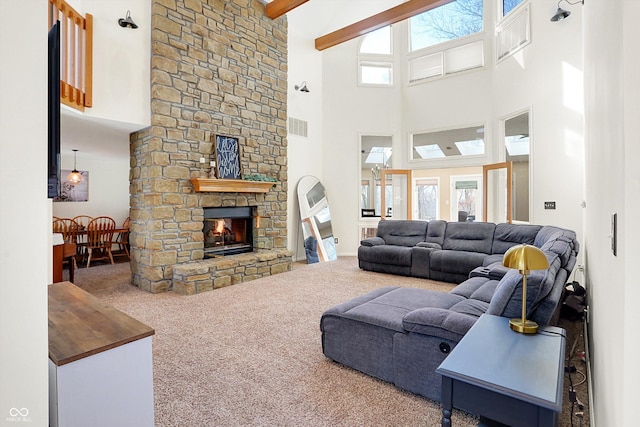 living room featuring a fireplace, a high ceiling, beamed ceiling, and carpet flooring