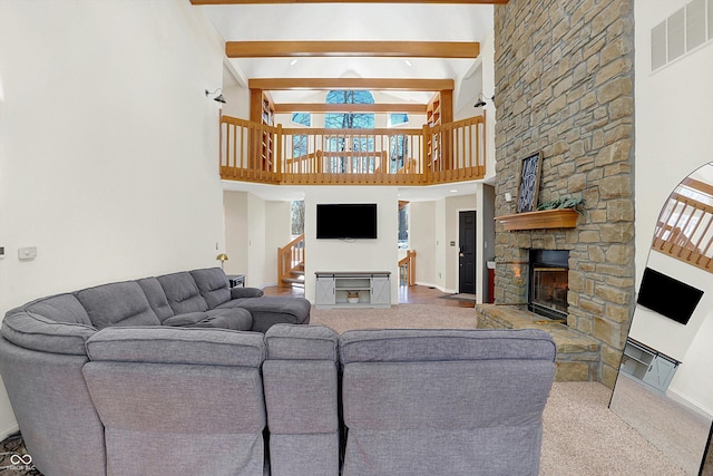 living room with a fireplace, beamed ceiling, and a high ceiling