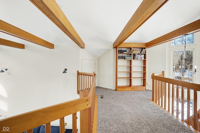 hall with carpet floors and beam ceiling