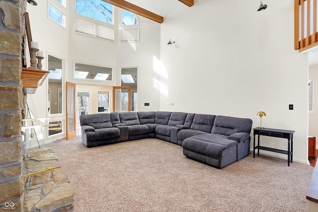 carpeted living room with a towering ceiling and beam ceiling