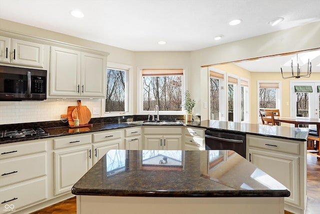 kitchen featuring sink, dark stone counters, and a kitchen island