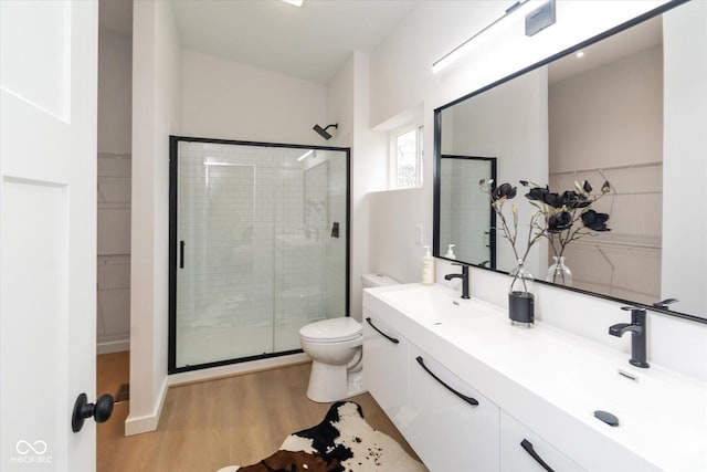 bathroom with vanity, toilet, an enclosed shower, and wood-type flooring