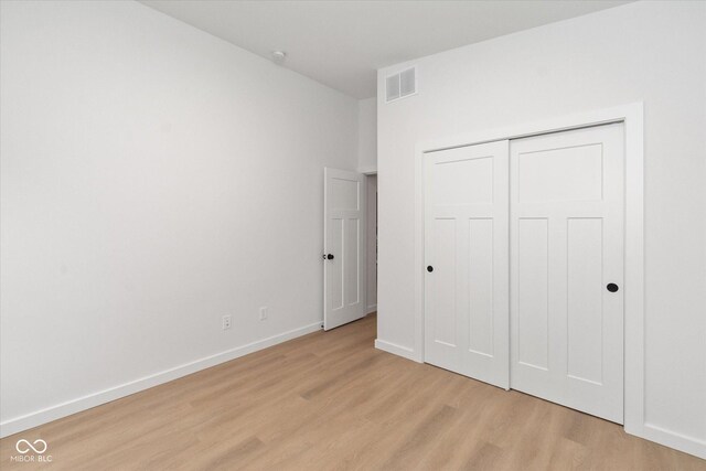 unfurnished bedroom with a closet and light hardwood / wood-style flooring