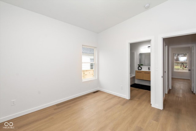 unfurnished bedroom featuring light hardwood / wood-style floors and lofted ceiling