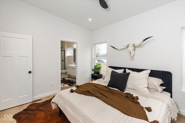 bedroom with ensuite bath, ceiling fan, and vaulted ceiling