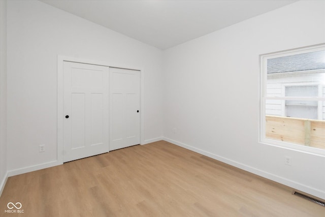 unfurnished bedroom with light hardwood / wood-style floors and a closet