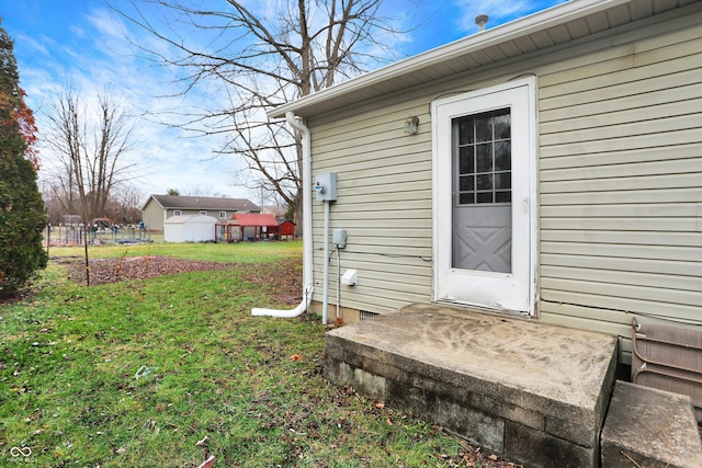 doorway to property featuring a lawn