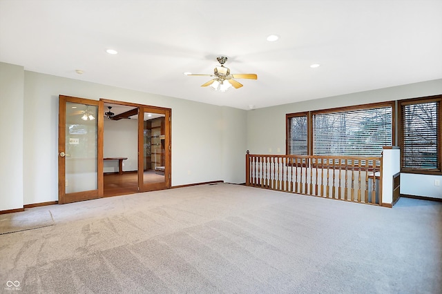 carpeted spare room featuring french doors and ceiling fan