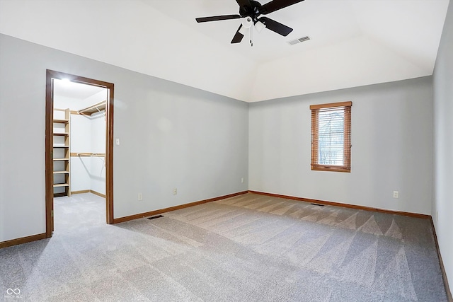 carpeted spare room featuring a tray ceiling and ceiling fan