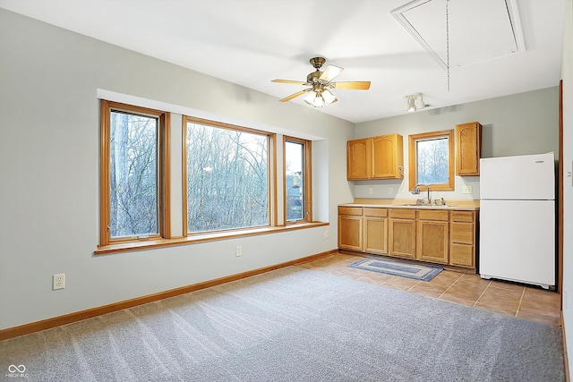 kitchen with ceiling fan, white refrigerator, sink, and light carpet