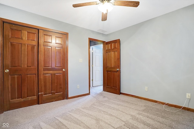 unfurnished bedroom with ceiling fan, a closet, and light carpet