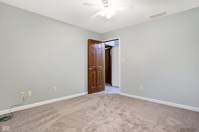 carpeted spare room with ceiling fan