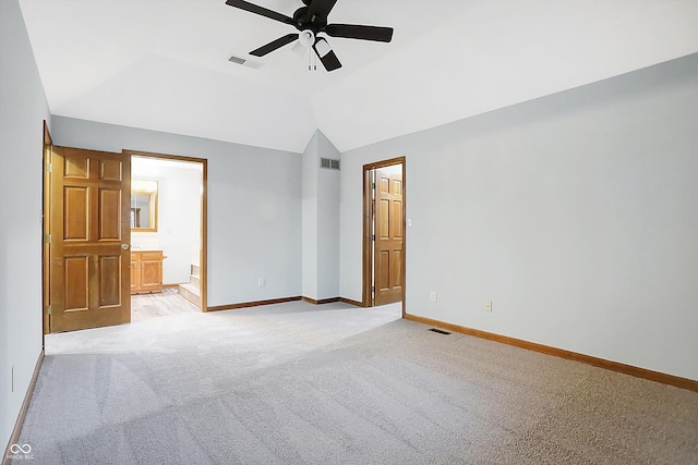 unfurnished bedroom with ceiling fan, lofted ceiling, light carpet, and ensuite bath