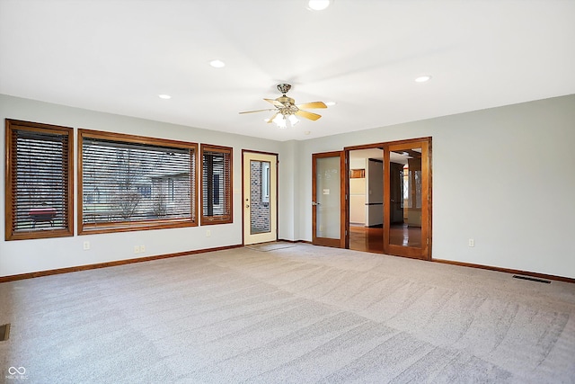 carpeted spare room with french doors and ceiling fan