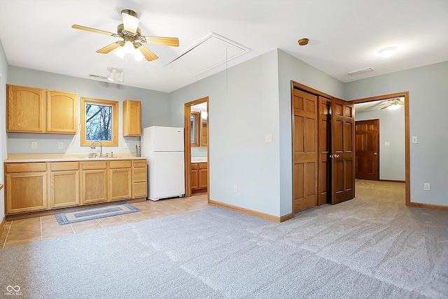 kitchen featuring light carpet, sink, white fridge, and ceiling fan