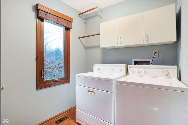 washroom with cabinets, independent washer and dryer, and light hardwood / wood-style flooring