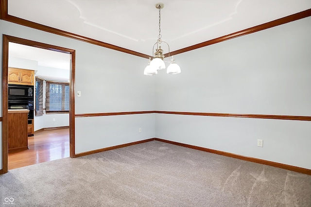 carpeted spare room featuring crown molding