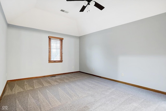 carpeted empty room featuring a tray ceiling, ceiling fan, and lofted ceiling