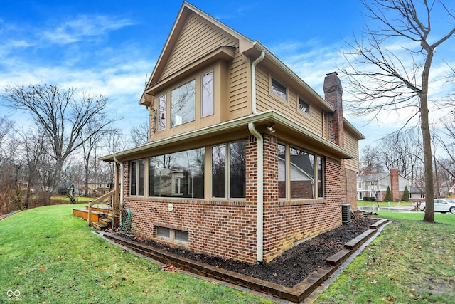 view of side of property with a yard and a sunroom