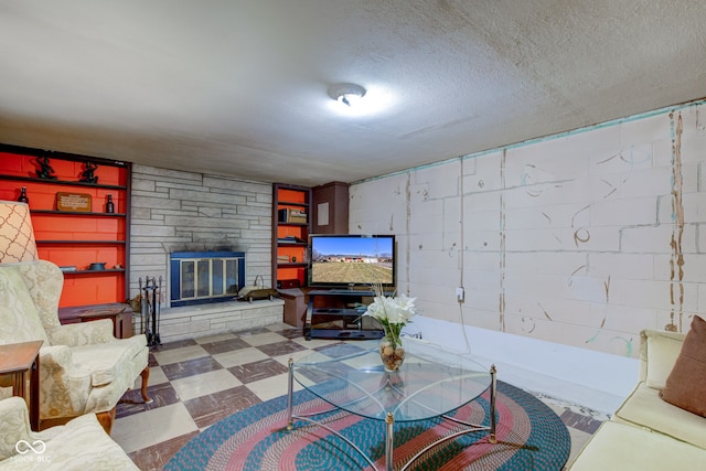 living room featuring a stone fireplace and a textured ceiling