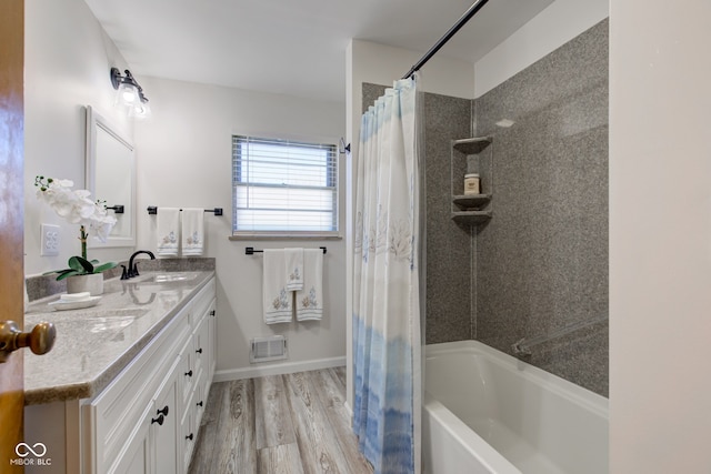 bathroom featuring hardwood / wood-style flooring, vanity, and shower / bath combo