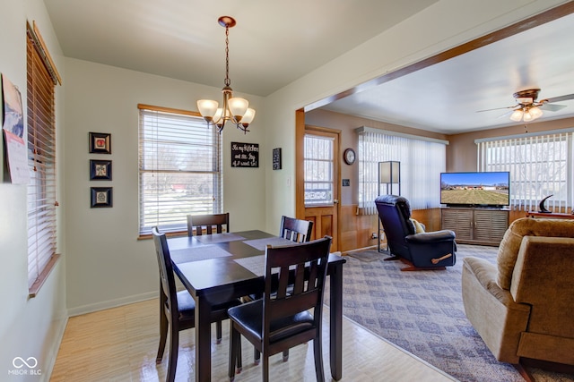 dining room with ceiling fan with notable chandelier and light wood-type flooring