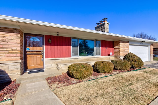 property entrance featuring a garage and a lawn