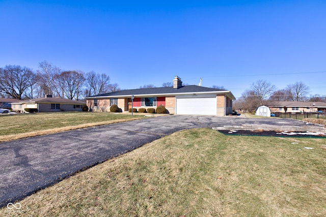 ranch-style home with a garage and a front lawn