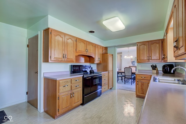 kitchen with an inviting chandelier, sink, black electric range, and light hardwood / wood-style flooring