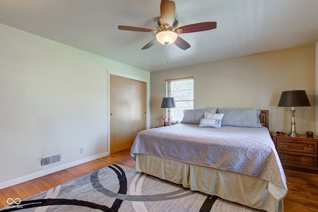 bedroom with ceiling fan, wood-type flooring, and a closet