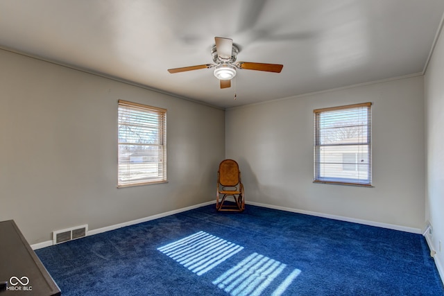 carpeted empty room with a wealth of natural light, ornamental molding, and ceiling fan