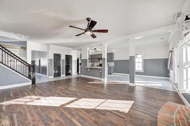 unfurnished living room with ceiling fan, dark wood-type flooring, and a textured ceiling