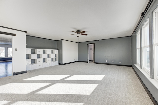 carpeted empty room featuring ceiling fan and ornamental molding