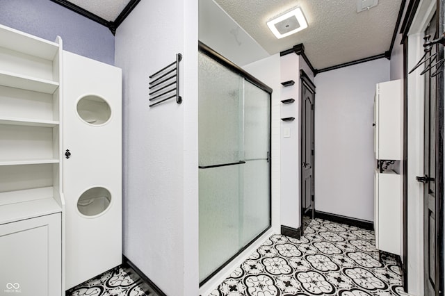 bathroom with a textured ceiling, crown molding, and an enclosed shower