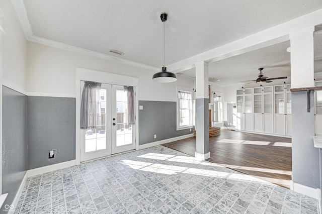 interior space featuring a textured ceiling, ceiling fan, crown molding, and french doors