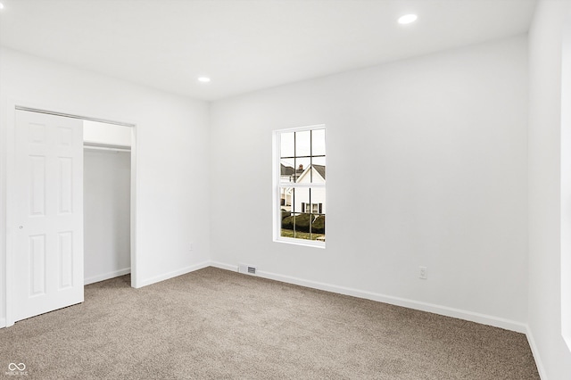 unfurnished bedroom featuring carpet and a closet