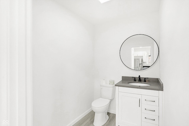 bathroom with vanity, wood-type flooring, and toilet