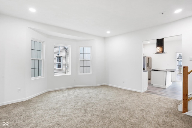 unfurnished room featuring light colored carpet