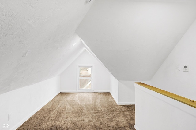 bonus room featuring carpet flooring, a textured ceiling, and lofted ceiling