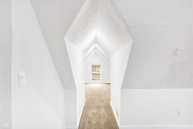 bonus room featuring a textured ceiling, carpet floors, and vaulted ceiling