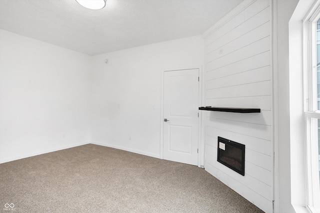 unfurnished living room featuring carpet and a large fireplace