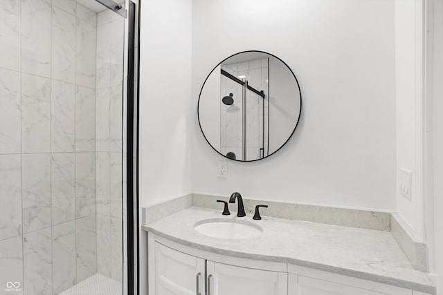 bathroom with vanity and a shower with door