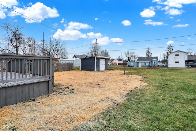 view of yard with a pool side deck and a storage shed