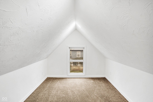 bonus room with vaulted ceiling, carpet, and a textured ceiling